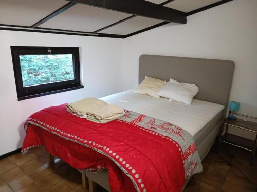 科克赛德Maison Sunpark Oostduinkerk 550的一间卧室配有一张床铺,床上铺有红色毯子