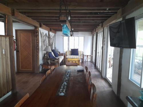蒙特里科Casa, Cabo Tortugas, Monterrico的客厅配有长桌、椅子和平面电视。