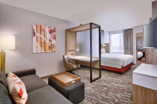 盐湖城SpringHill Suites by Marriott Salt Lake City Sugar House的酒店客房设有一张沙发和一张床