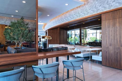 蒙特雷AC Hotel by Marriott Monterrey Valle的餐厅拥有木墙和蓝色的椅子