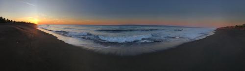 蒙特里科Casa, Cabo Tortugas, Monterrico的日落时分享有海滩和大海的景致