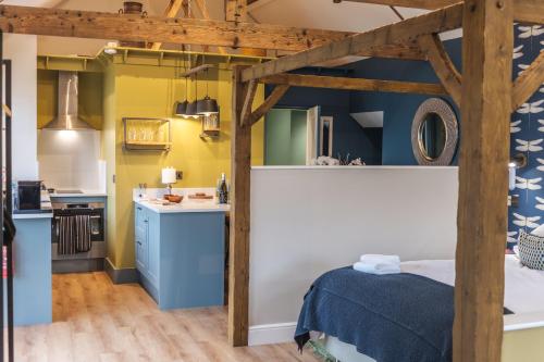 达灵顿The Woodshop的一间设有床铺的客房和一间带黄色墙壁的厨房
