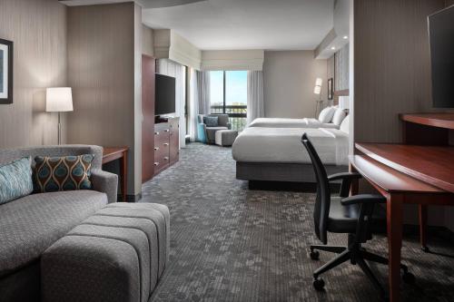 卡胡卢伊毛伊岛卡胡鲁伊机场万怡酒店的酒店客房配有一张床、一张书桌和一张书桌。
