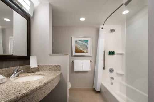 卡胡卢伊毛伊岛卡胡鲁伊机场万怡酒店的白色的浴室设有水槽和淋浴。