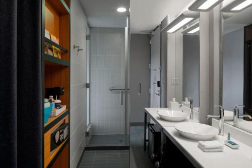 罗杰斯罗杰斯本顿维尔雅乐轩酒店的一间带两个盥洗盆和淋浴的浴室