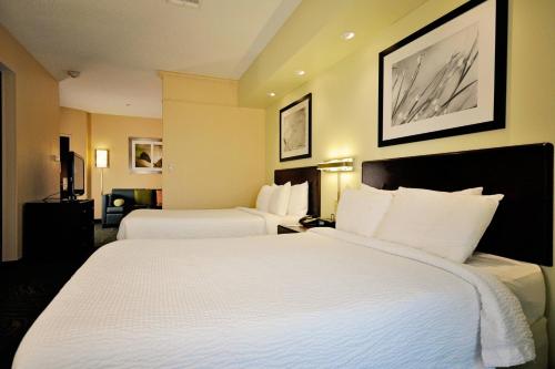 加尔维斯敦加尔维斯顿岛春季山丘套房酒店的酒店客房,配有两张带白色床单的床