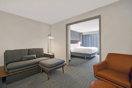 埃尔姆赫斯特芝加哥艾姆赫斯特/奥克布鲁克地区万怡酒店的酒店客房设有沙发、床和镜子