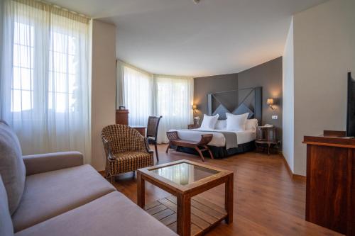 擞莫托雷斯德索莫酒店的酒店客房配有床、沙发和桌子。