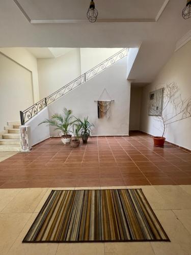 马萨阿拉姆La Casa Guest House的一间设有楼梯和地毯的大房间