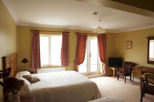韦斯特波特海点之家住宿加早餐旅馆的一间卧室配有一张床、一张书桌和两个窗户。