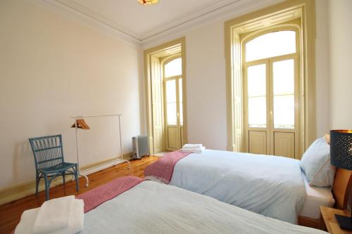 菲盖拉-达福什Casa 11 Cravos的一间卧室设有两张床、一把椅子和一个窗户。