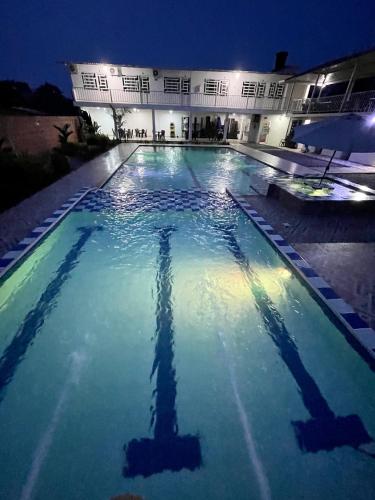 阿卡西亚斯BAHIA MALECON的一座大型游泳池,晚上与大楼相连