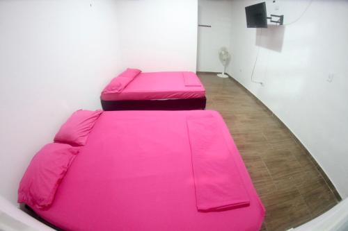 阿卡西亚斯BAHIA MALECON的一张大粉红色沙发坐在房间里