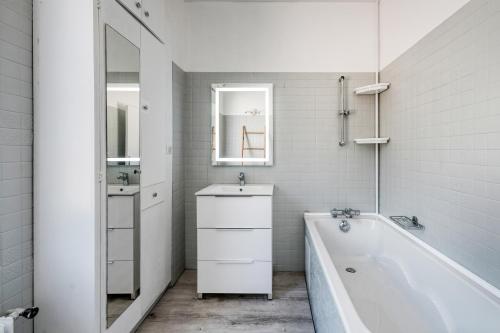 埃夫勒Magnifique maison pleine de charme ideale jeux olympiques un kilometre de la gare的白色的浴室设有浴缸和水槽。