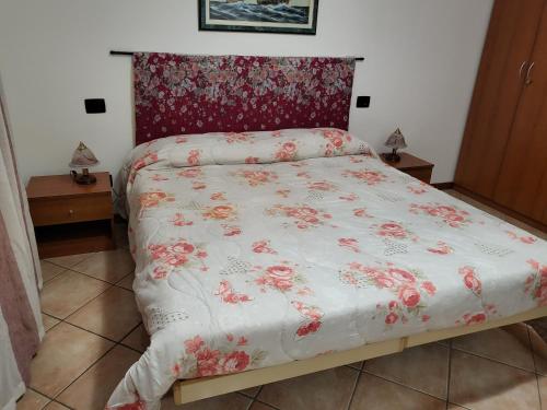 诺瓦拉Dantino的一张带白色棉被和红色鲜花的床
