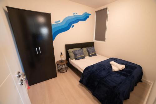 伦敦Spacious and Stylish 1 Bed Modern Flat的一间卧室配有一张带蓝色毯子的床