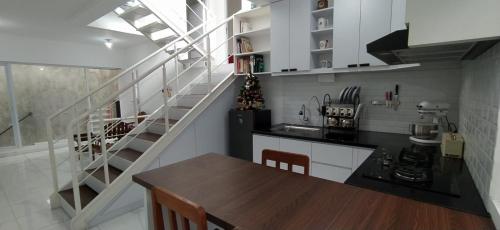 BonorejoRumah Bahagia 36的厨房设有木桌和楼梯。