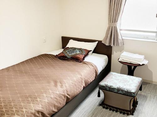 横滨Guesthouse La Cava women's single room / Vacation STAY 21865的一间卧室设有一张床、一个窗口和一张桌子