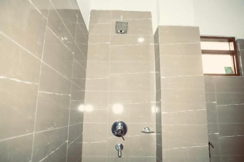 索拉哈Hotel Nepal Inn Sauraha的带淋浴的浴室(带石墙)