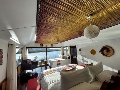 普诺Uros Lodge Perú的一间卧室配有一张床、一张沙发和一张桌子