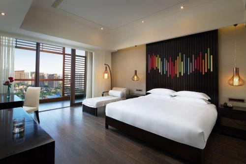 三亚三亚湾红树林度假世界椰林酒店的卧室配有一张白色大床和色彩缤纷的墙壁。