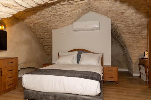 拿撒勒Saint Jacob Hotel的一间卧室设有一张带石墙的大床