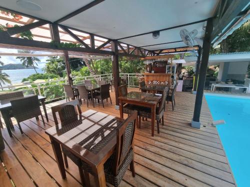普拉兰Mirella Villa Ocean View Villa的游泳池旁的木甲板上配有桌椅