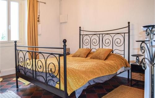 Castel-Sarrazin2 Bedroom Cozy Home In Castel-sarrazin的一间卧室配有一张带锻铁框架的床