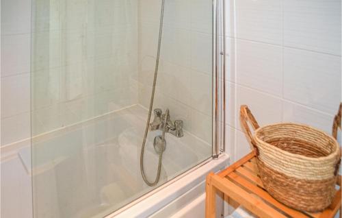 Castel-Sarrazin2 Bedroom Cozy Home In Castel-sarrazin的浴室里设有淋浴,桌子上有一个篮子