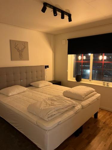 韦姆达伦Storhogna Torg的卧室配有一张大白色床和窗户