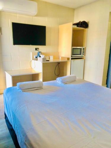 坎纳马拉OXFORD HOTEL MOTEL的一间卧室设有一张大蓝色的床和电视