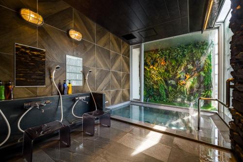 静冈橡树静冈酒店的带浴缸的浴室和墙上的绘画