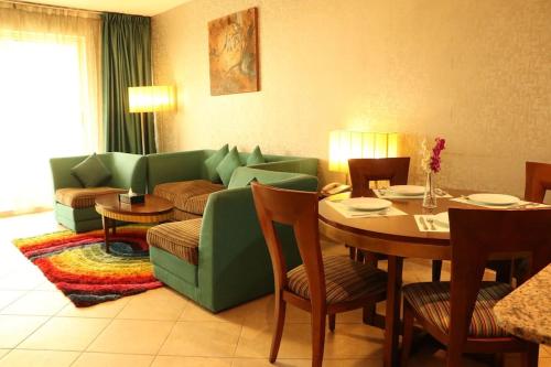 迪拜艾尔马纳尔公寓大酒店的客厅配有绿色沙发和桌子