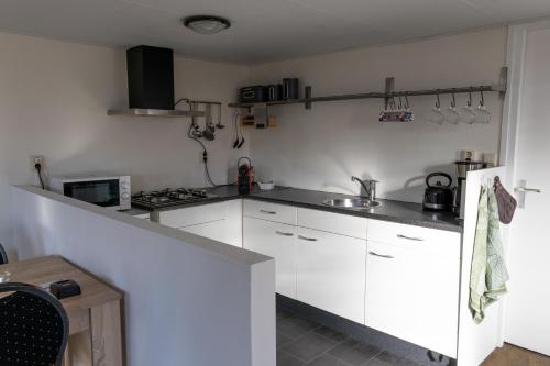 安卢Luxe Chalet Strubben-Kniphorstbos Anloo的厨房配有白色橱柜和台面