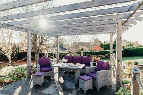 安格斯Large Holiday Home perfect for family gatherings的一个带紫色椅子和一张桌子的木制凉亭