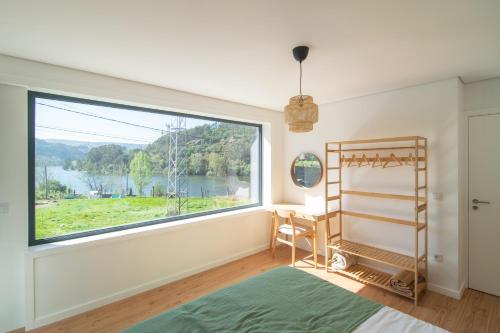 派瓦堡Costa D'Ouro的一间卧室设有大窗户、一张床和一张书桌