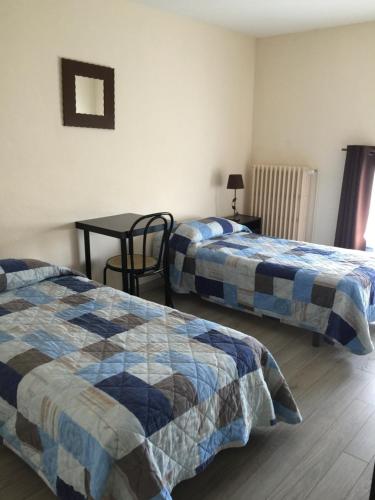 萨路特德沃克吕兹西尼奥雷酒店的客房设有两张床和一张桌子