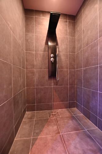 弗卢瓦拉克SECRET33的墙上设有带吹风机和淋浴的浴室