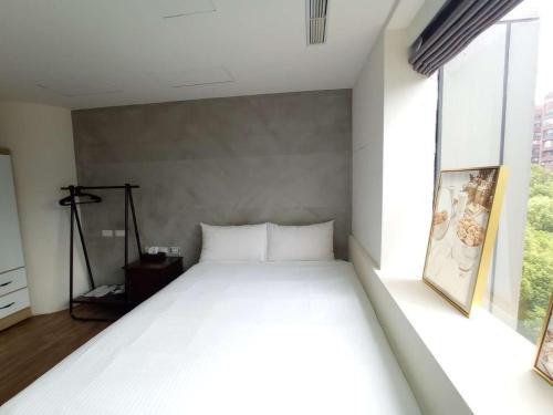 台北幸福米窝 的配有大窗户的客房内的白色床