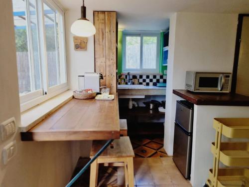 Netiv HaLamed Heיחידת אירוח נעם的厨房配有木桌和微波炉