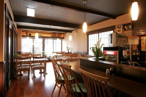 函馆辺见旅馆的一间带木桌椅的餐厅和一间酒吧