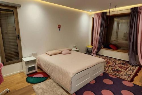马拉喀什Villa moderne avenue M6的一间卧室设有床、两个窗户和地毯。