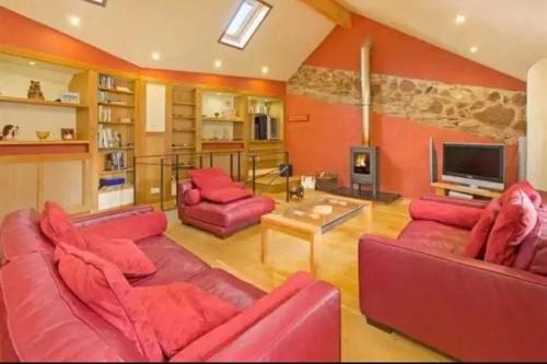 牛顿阿伯特Mill Cottage Garden Annexe的客厅配有红色家具和电视