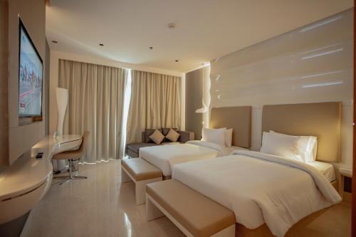 艾恩Alberni Jabal Hafeet Hotel Al Ain的酒店客房配有两张床和一张书桌
