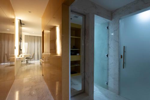艾恩Alberni Jabal Hafeet Hotel Al Ain的一间带玻璃门和书桌的浴室