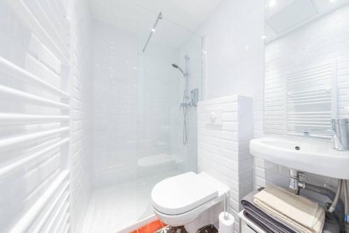 巴黎Sacré Petit Studio in the Coeur of Montmartre的白色的浴室设有卫生间和水槽。