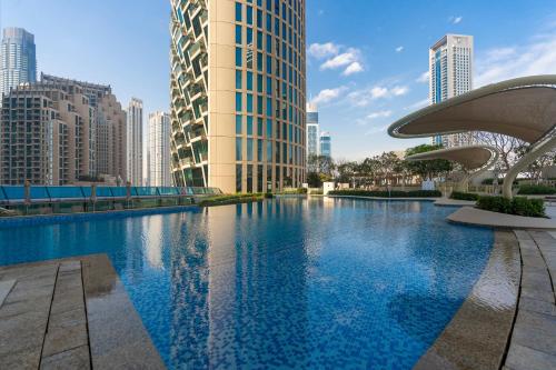 迪拜Prestige Living 1BR with Full Burj Khalifa View by Auberge的一座位于城市的游泳池,有高大的建筑