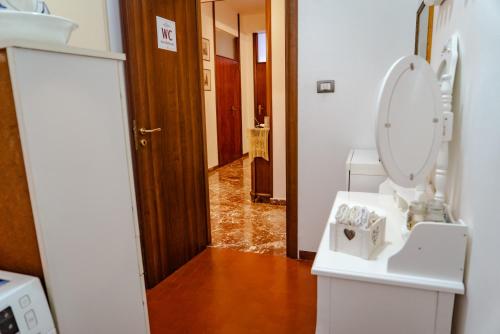 墨西拿Antiquarium Messina的一间带卫生间和水槽的浴室以及走廊