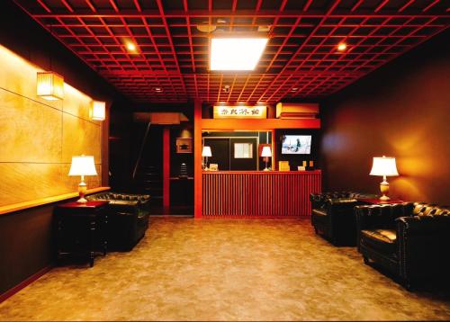 奈良Nara Ryokan的一间带椅子的房间和一间带电视的酒吧