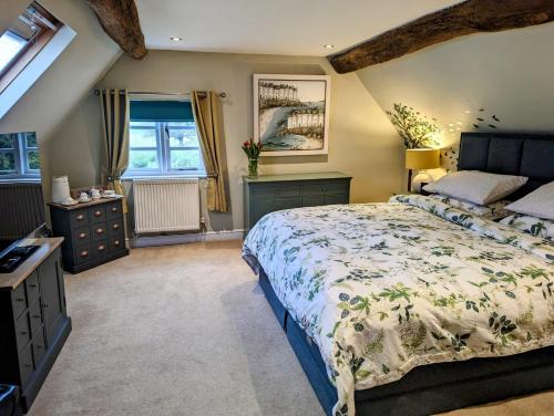 布由德利Worralls Grove Guest Farm House的一间卧室设有一张大床和一个窗户。